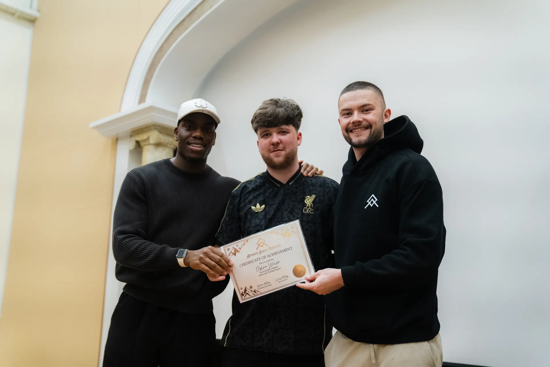 An Affinity graduate flanked by the two founders